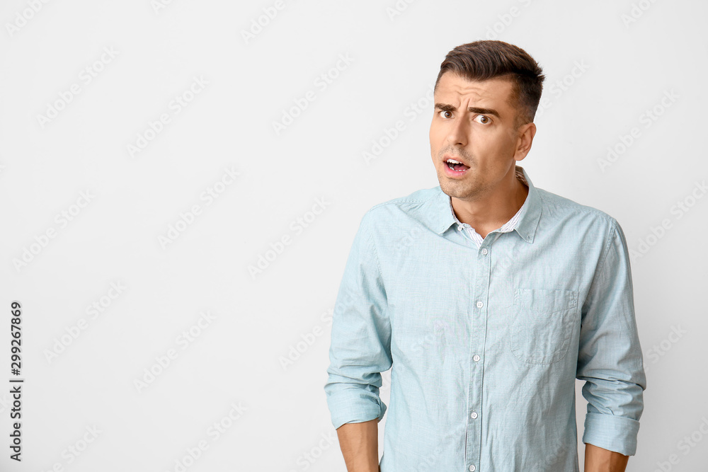 Suspicious young man on light background