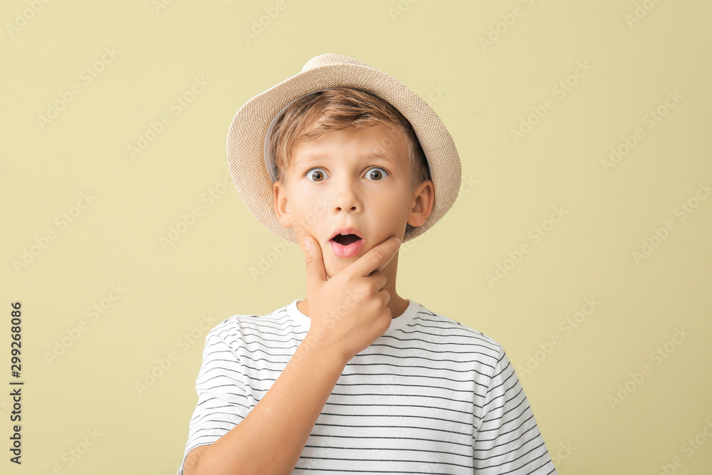 Surprised little boy on color background