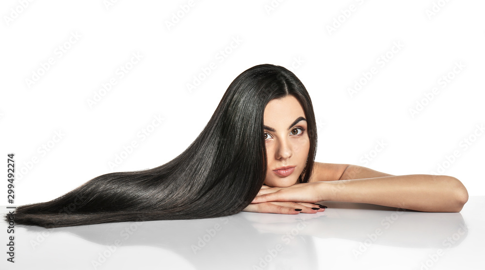 Portrait of beautiful young woman with healthy long hair on white background