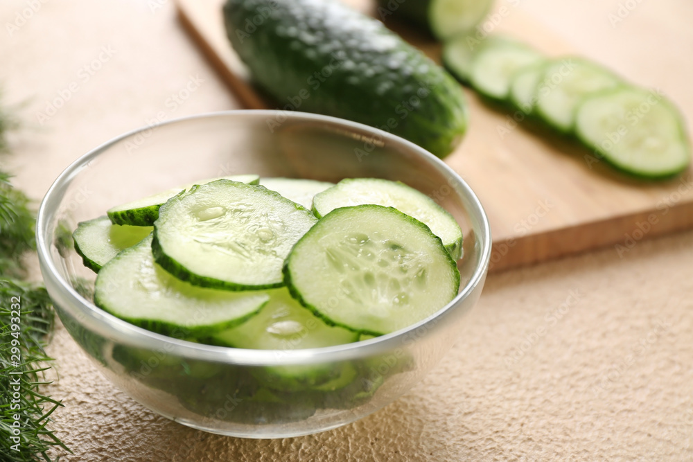 Bowl with fresh cut cucumber on table