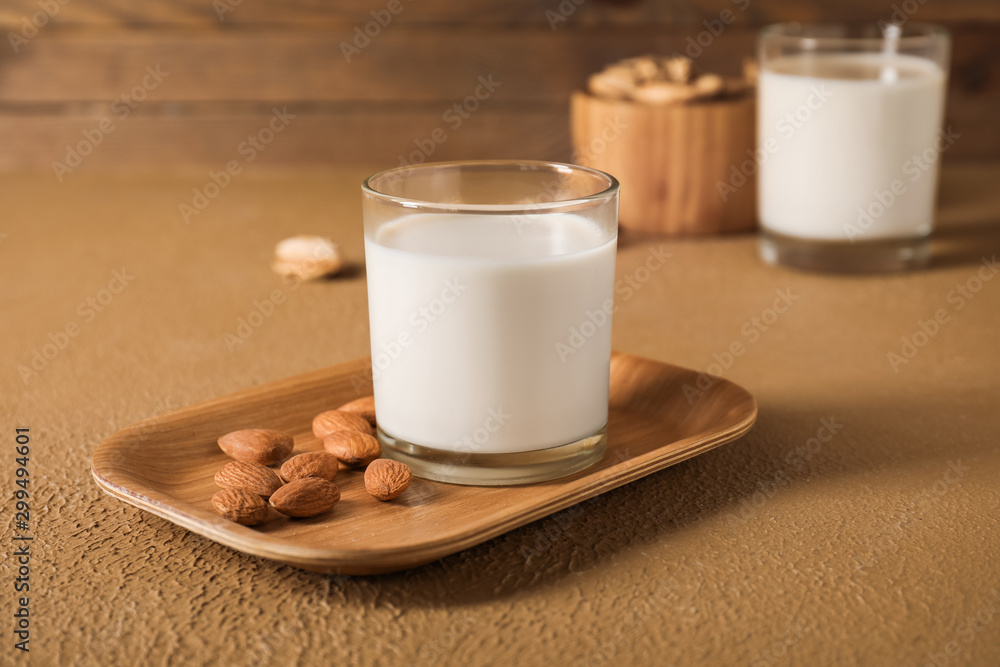 Glass of tasty almond milk on table