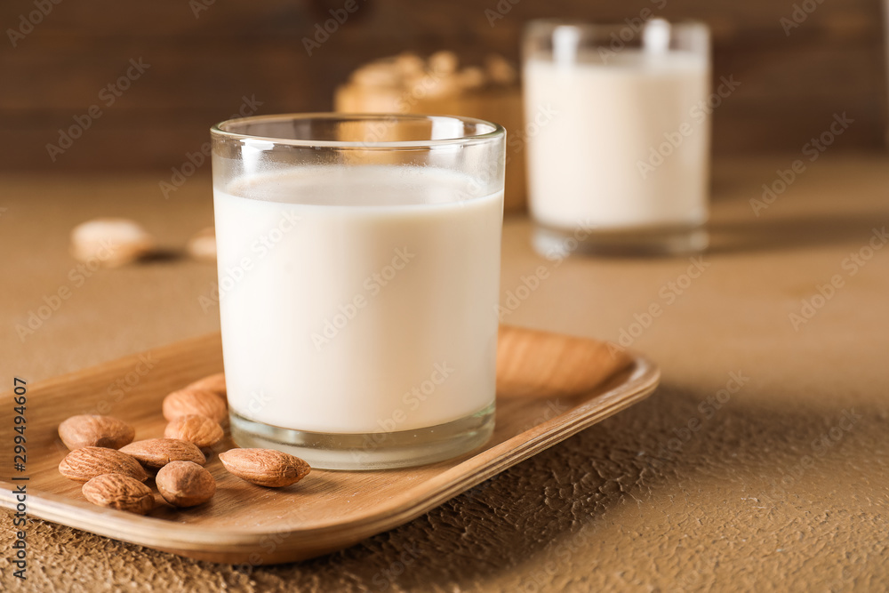 Glass of tasty almond milk on table