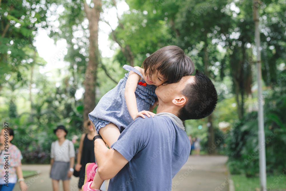 Portrait of young father carrying his daughter on his back