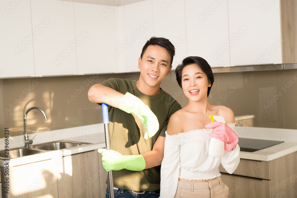 Housewife and her husband cleaning home and having fun together. Housekeeping, home cleaning and cle