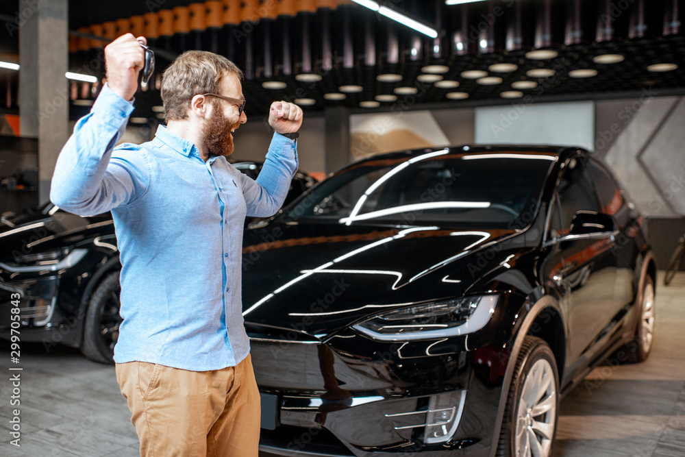 Portrait of a man near electric car at the showroom