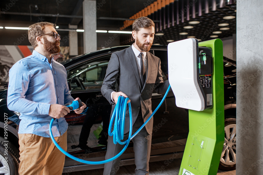 Customer with a seller at the showroom with car charges