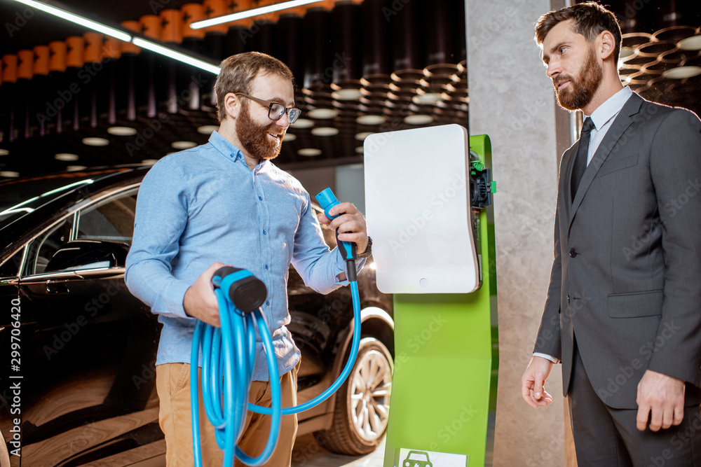 Customer with a seller at the showroom with car charges