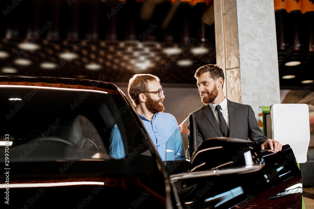 Client with a salesman at the showroom with electric cars