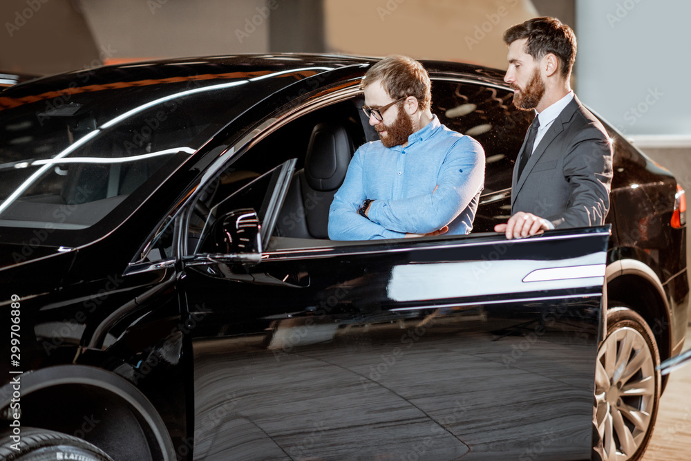 Client with a salesman at the showroom with electric cars