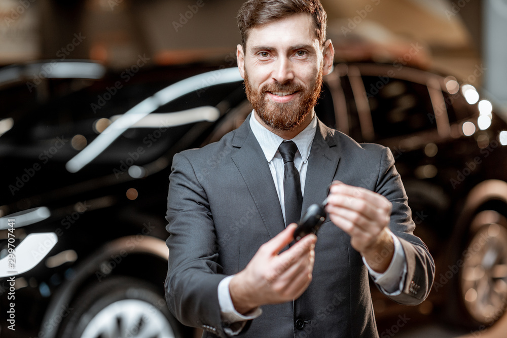 Salesman with key at the car dealership