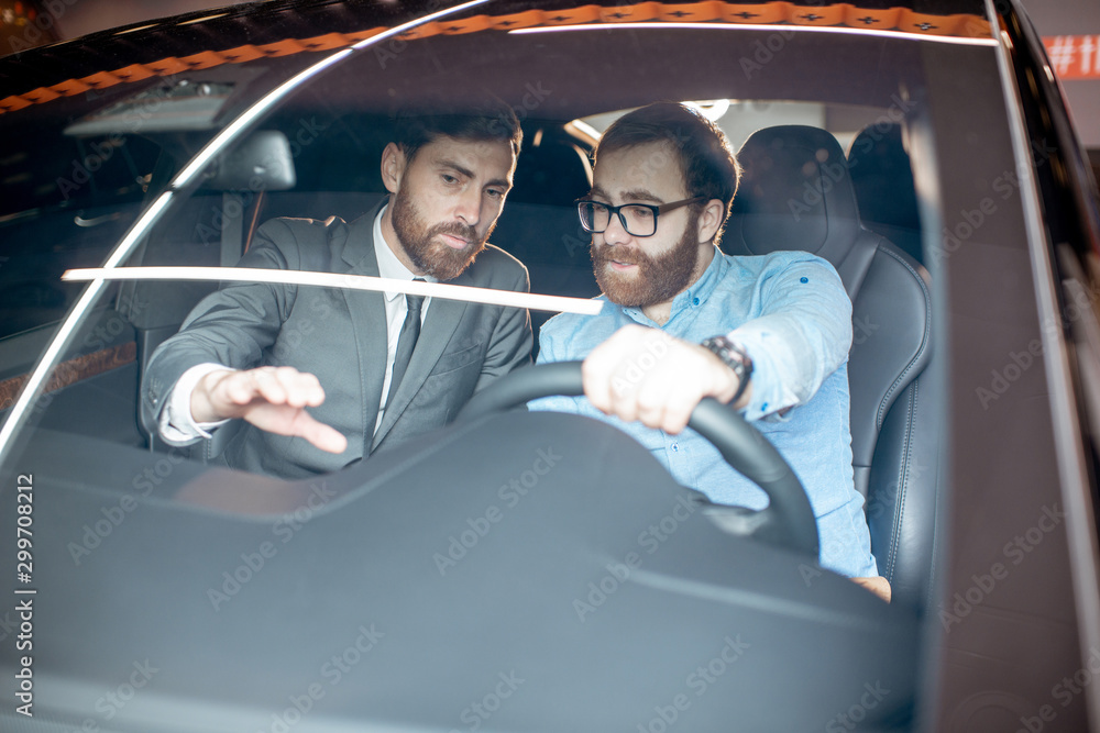 Sales manager with a client looking at the vehicle interior