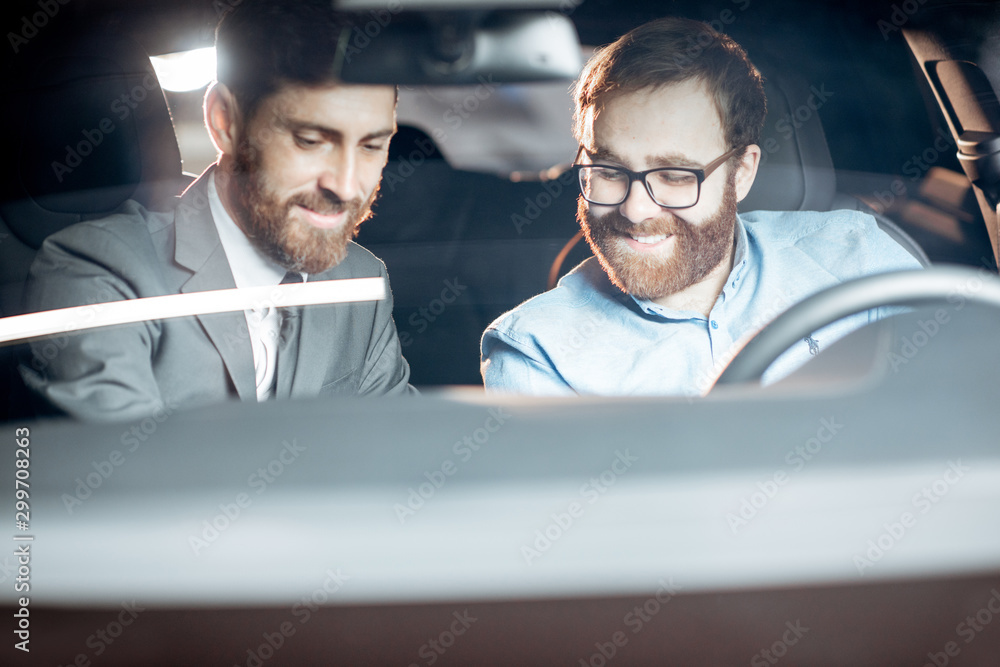 Sales manager with a client looking at the vehicle interior