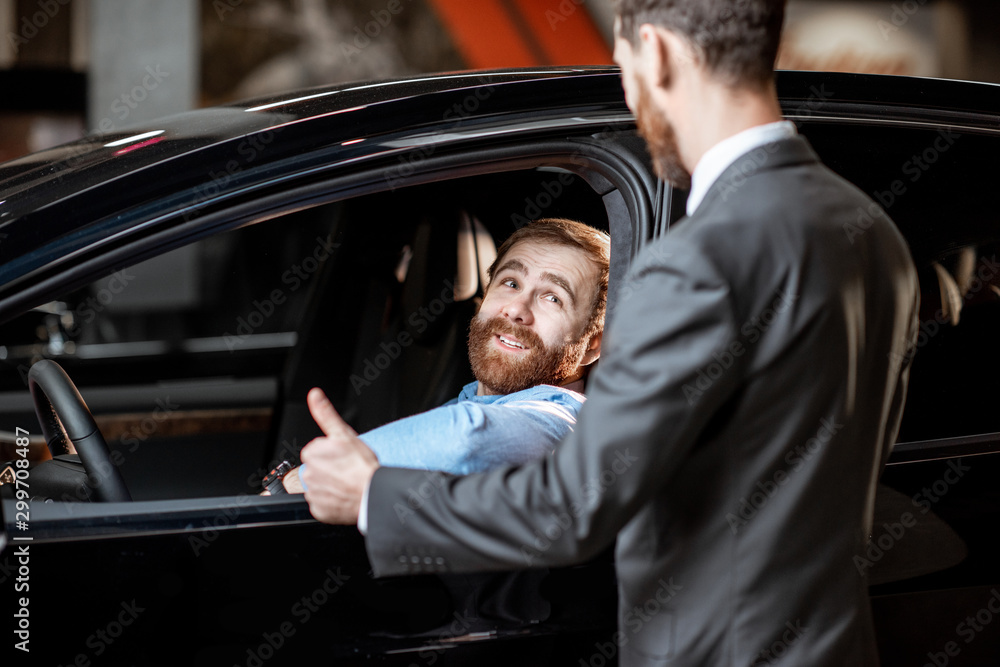 Sales manager with a client looking at the vehicle interior