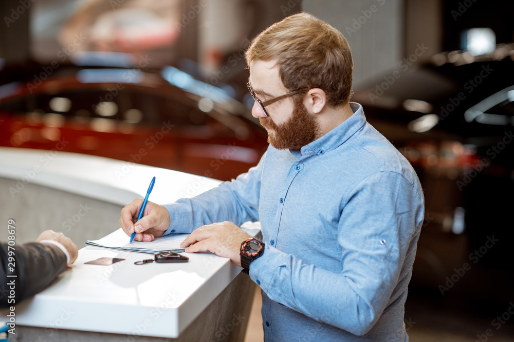 Man buying a new car at the dealership