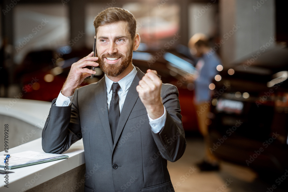 Businessman with car key in the showroom