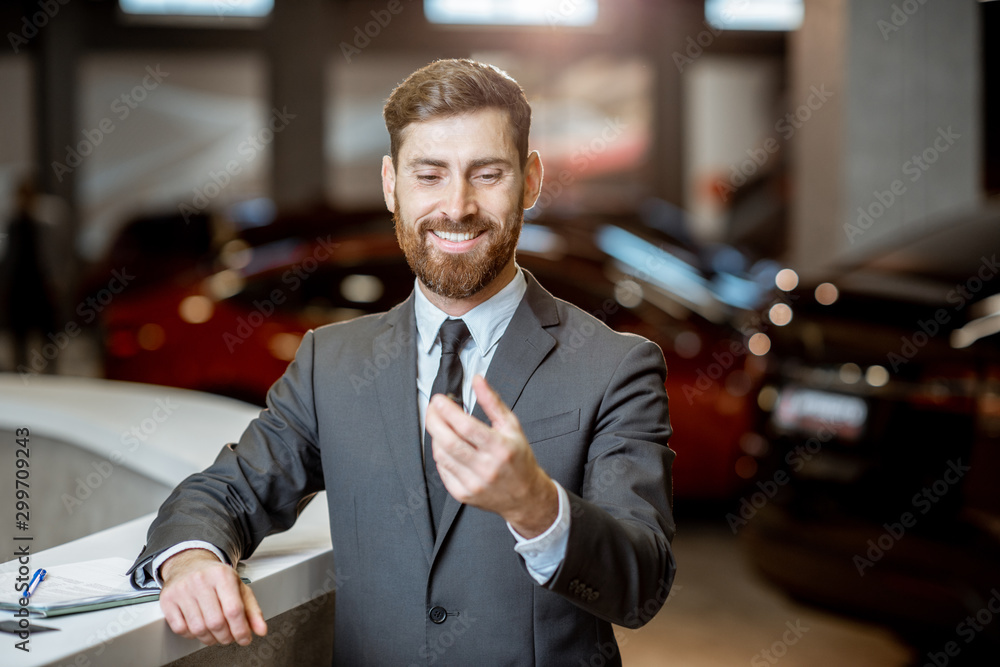 Businessman with car key in the showroom