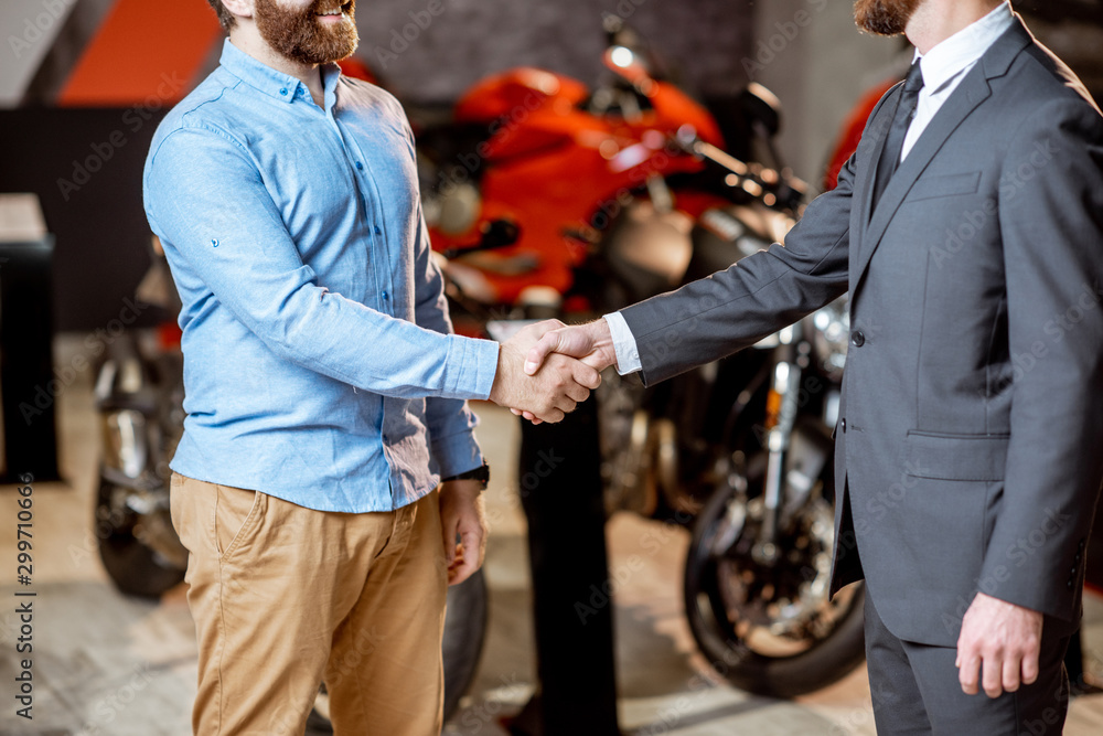 Handshake in the showroom with motorcycles