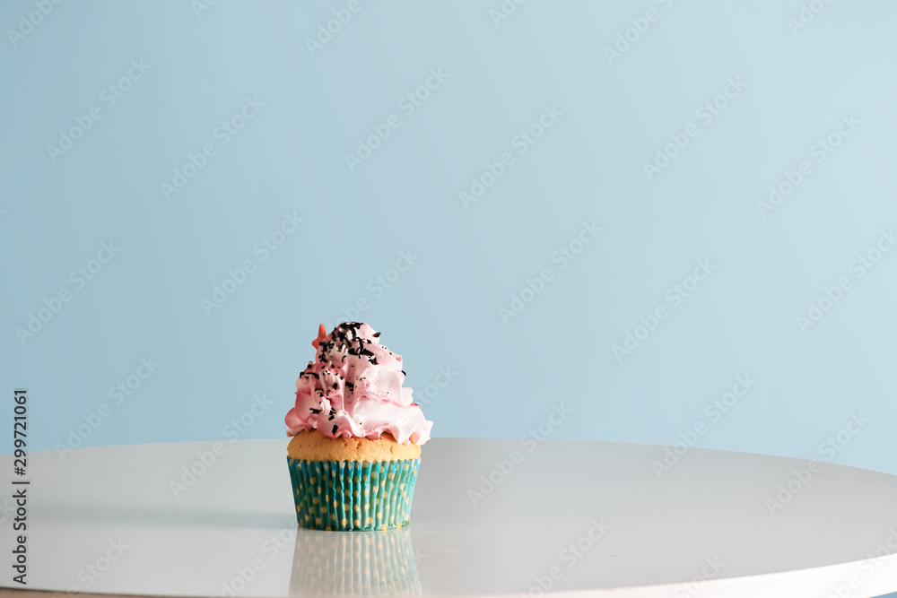 Cupcake with pink cream icing on table