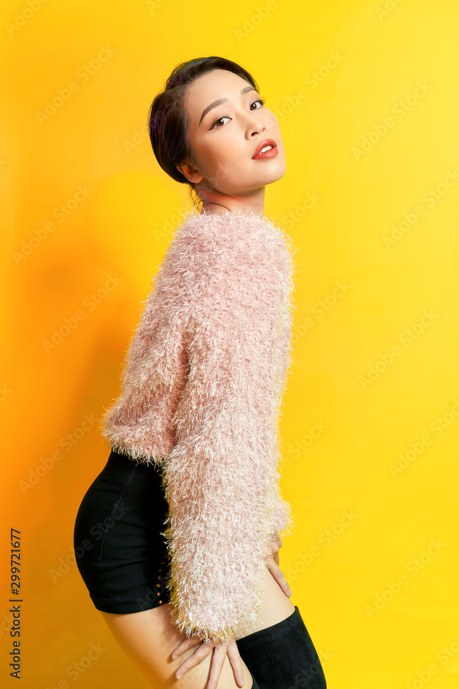 Adorable woman expressing true positive emotions during photoshoot in pink fur coat. Indoor portrait