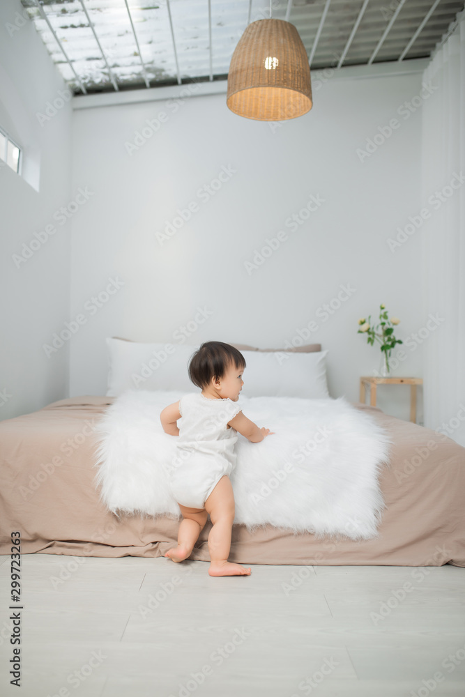 little child baby boy close up, standing near bed in bedroom