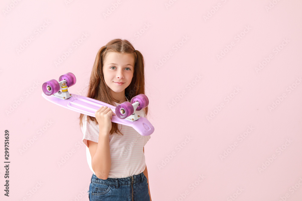 Stylish little girl with skateboard on color background