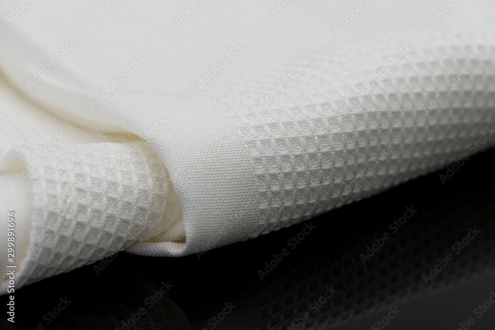 Macro shot texture of folded white towel kitchen fabric isolated on black background