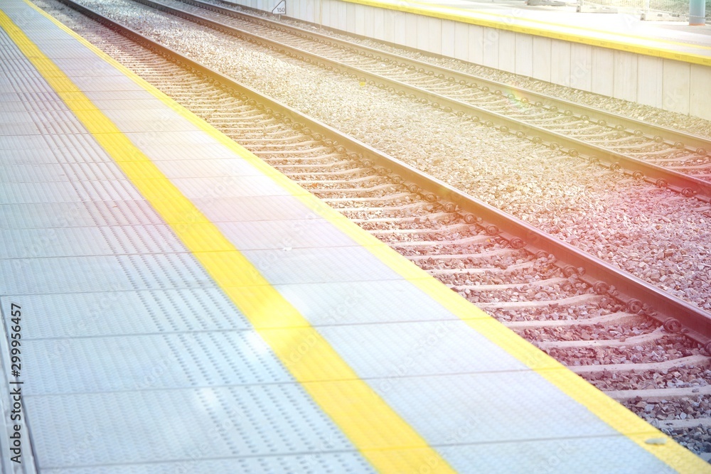  38/5000 Railroad tracks and platform in the light of the sun