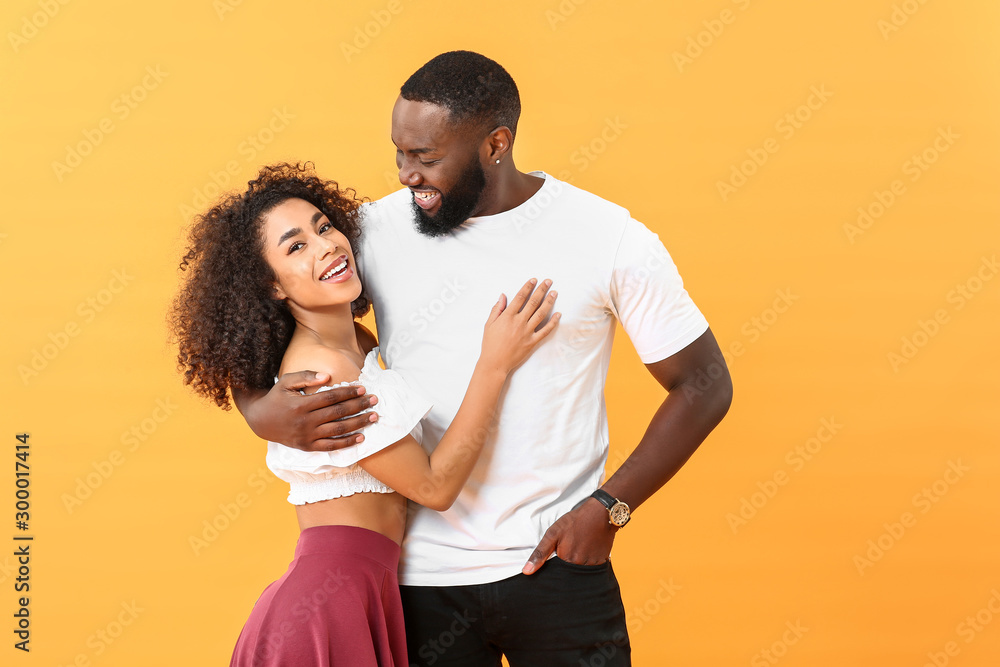 Portrait of happy African-American couple on color background