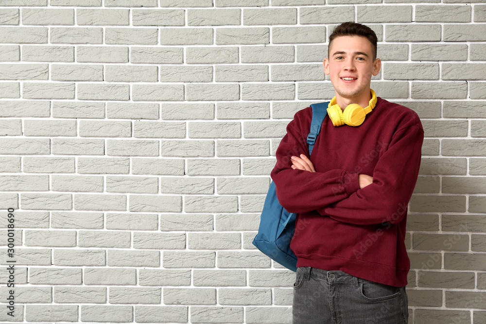 Portrait of teenage schoolboy on brick background