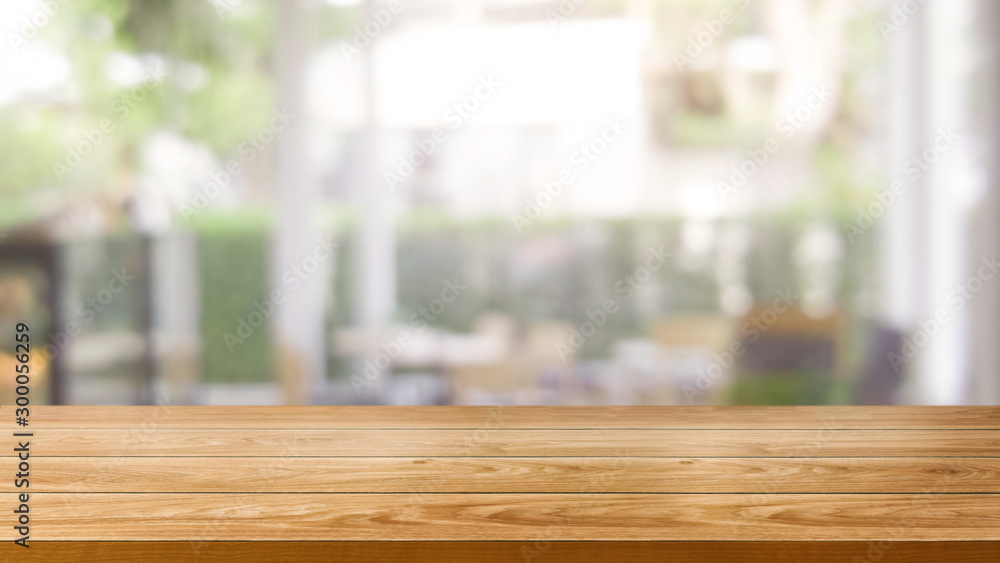 Wood table in blurry background of modern restaurant room or coffee shop with empty copy space on th