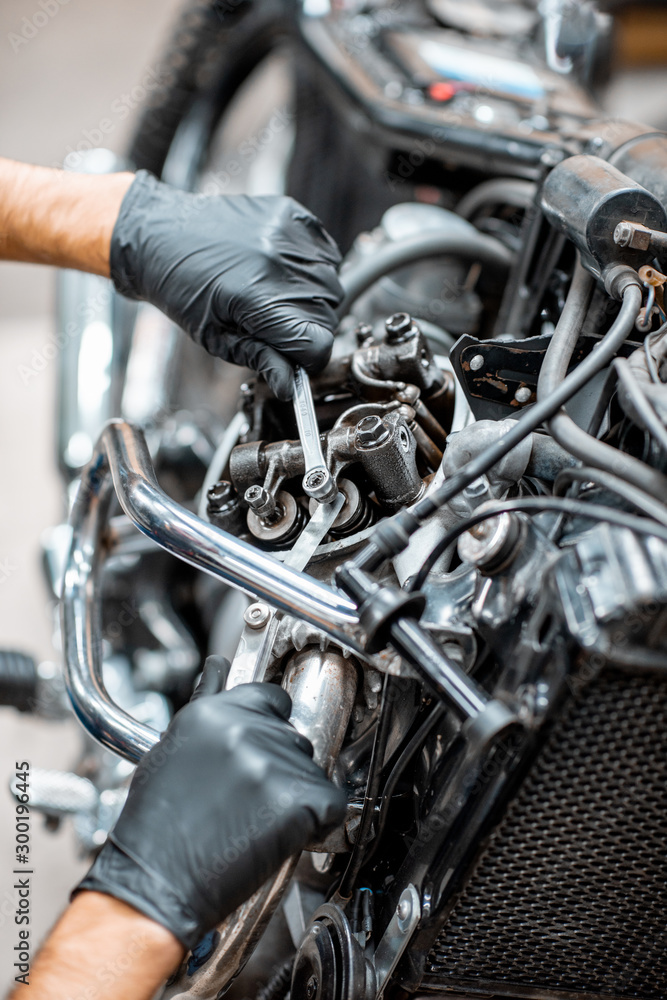 Worker repairing motorcycle engine at the workshop