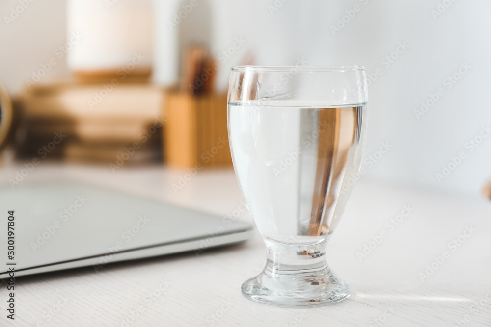 Glass of fresh water on table in room