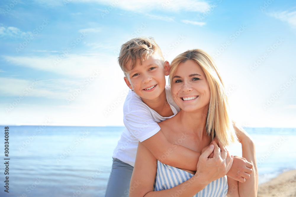 Portrait of happy mother and son on sea beach