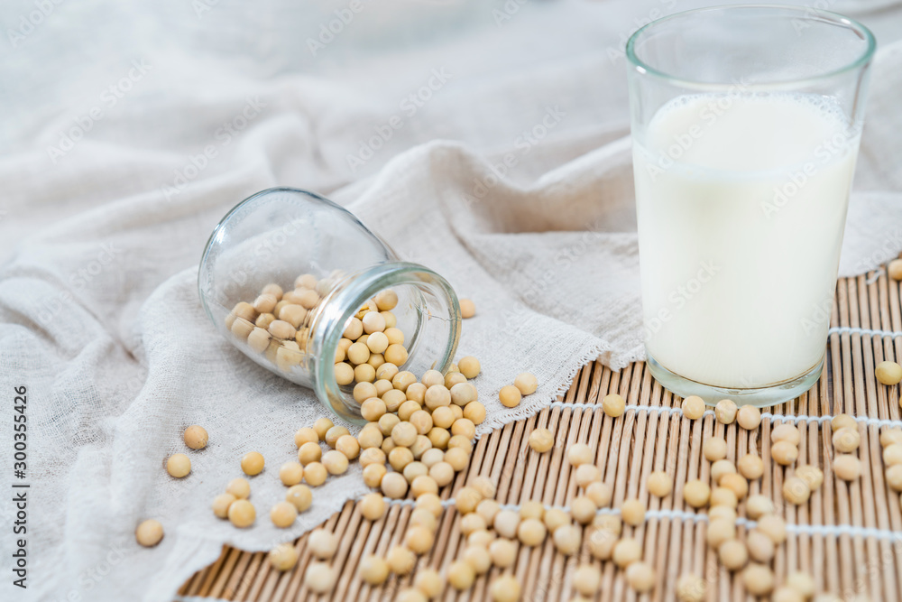 Many soybeans and a cup of soymilk on the bamboo mat