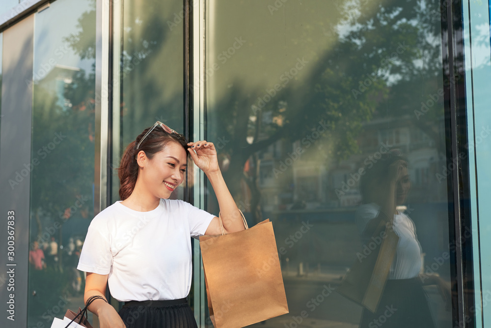 Shopping woman happy and looking away at copy space outdoors.