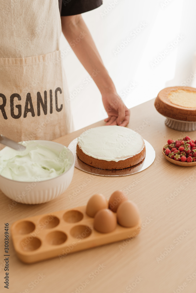 Pastry chef prepare putting cream on sponge cake. Making sponge cake process