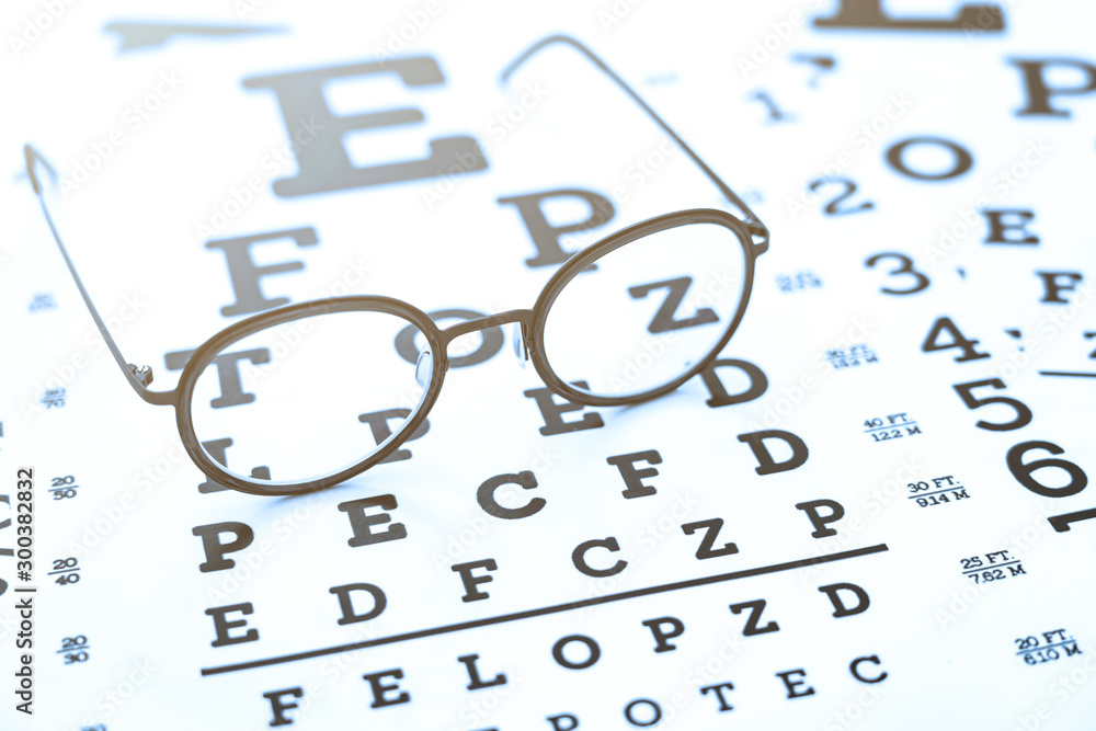 Black glasses on the eye chart with concept of vision protection