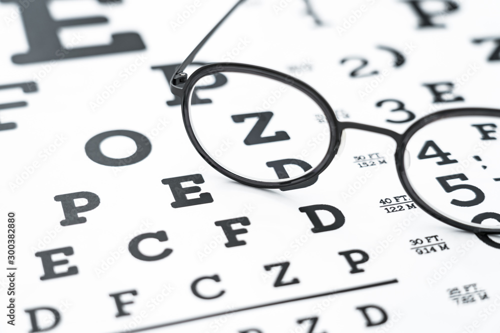 Black glasses on the eye chart with concept of vision protection