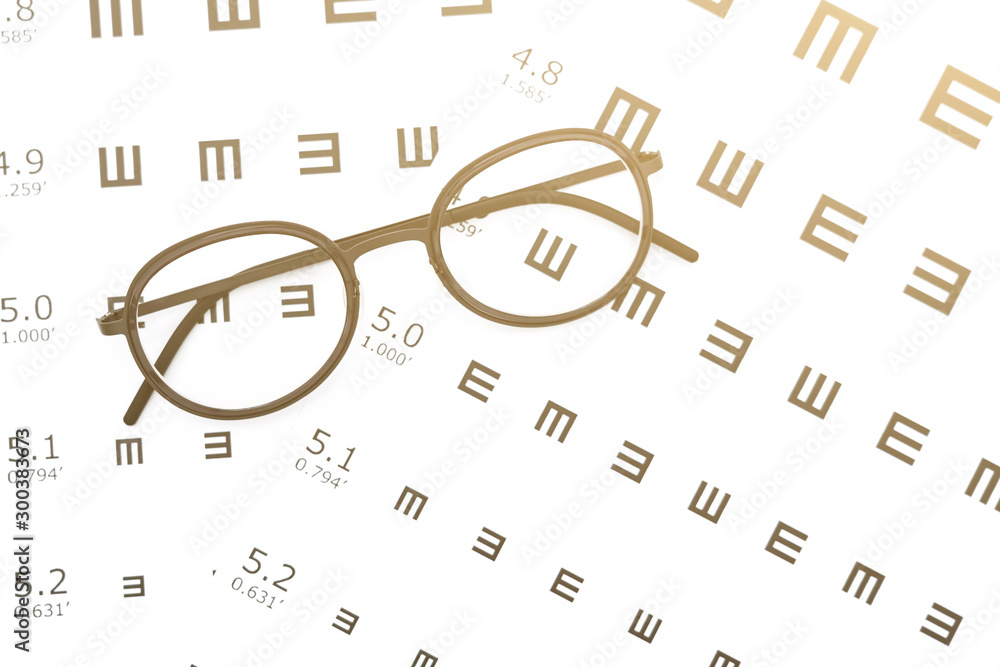 Black glasses on the eye chart with concept of vision protection