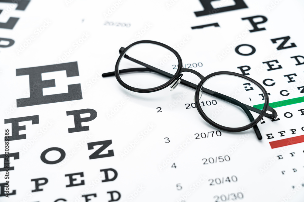 Black glasses on the eye chart with concept of vision protection