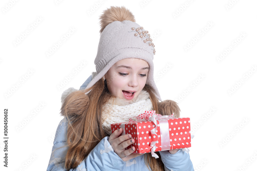 Happy little girl in warm clothes holding gift box