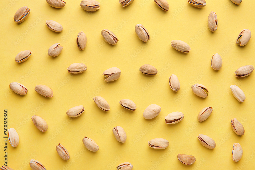 Tasty pistachio nuts on color background