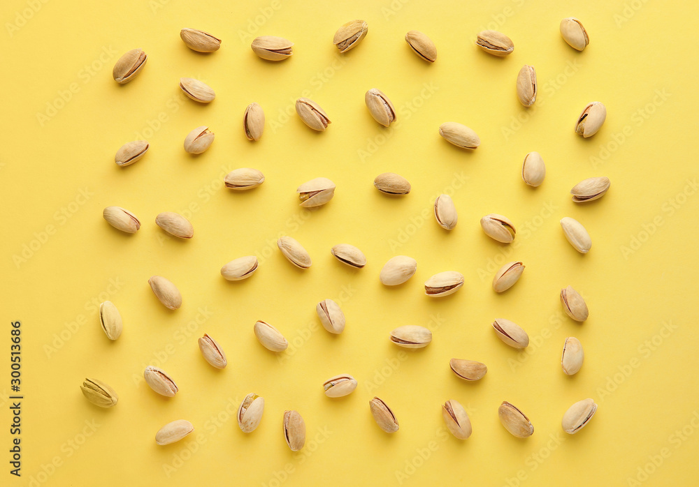 Tasty pistachio nuts on color background