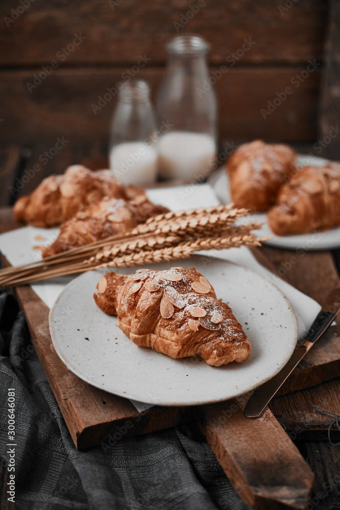 Almond croissant with custard filling on wood background.