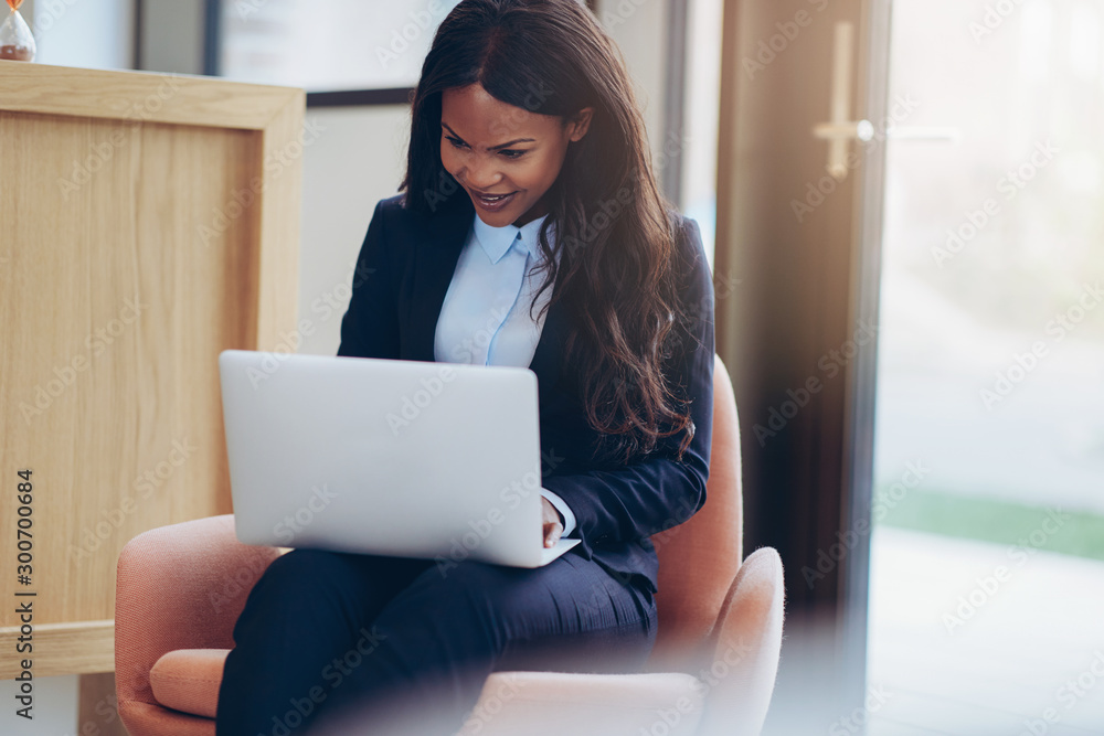 Smiling young African American businesswoman working on her lapt