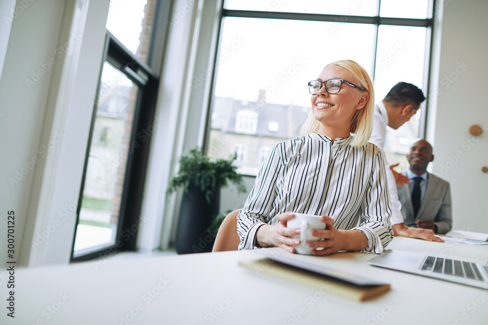 Smiling businesswoman enjoying a coffee during her office break