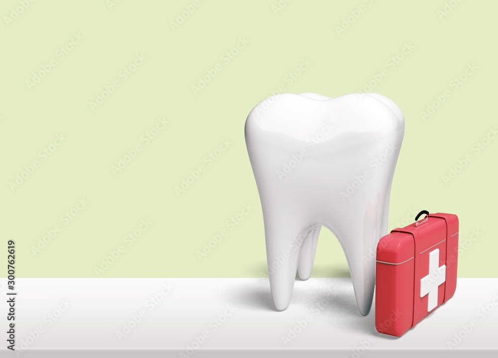 Large model of a tooth with a red first aid kit on a white table