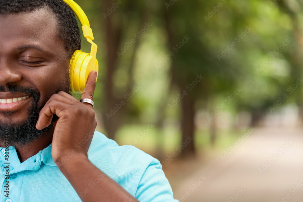 Handsome African-American man listening to music outdoors