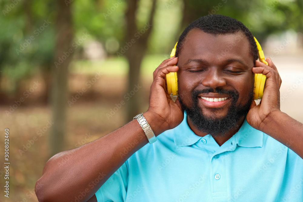 Handsome African-American man listening to music outdoors