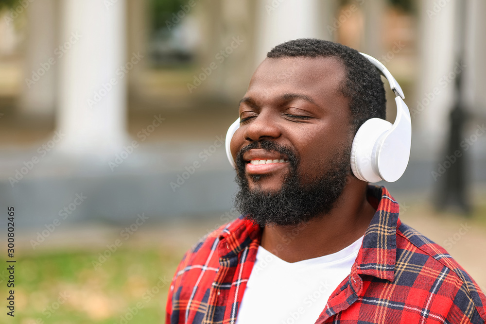 Handsome African-American man listening to music outdoors